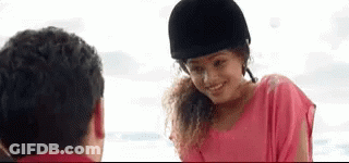 A Woman In A Pink Shirt And A Black Helmet Is Smiling At A Man . GIF