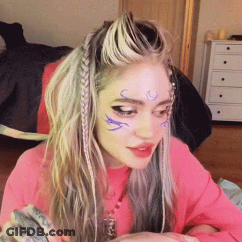 A Woman In A Pink Shirt Has A Tattoo On Her Forehead That Says ' I Love You ' GIF