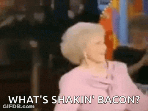 A Woman In A Pink Shirt Is Dancing And Saying What 'S Shakin ' Bacon . GIF