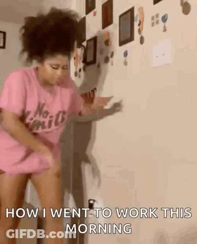 A Woman In A Pink Shirt Is Dancing In Front Of A Wall And Says " How I Went To Work This Morning " GIF