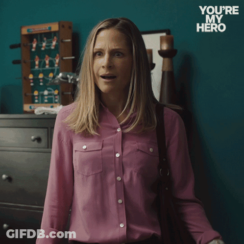 A Woman In A Pink Shirt Is Holding A Cell Phone And Says " Of Course " GIF