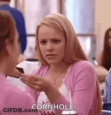 A Woman In A Pink Shirt Is Holding A Piece Of Cake In Her Hand And Talking To Another Woman . GIF