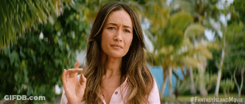 A Woman In A Pink Shirt Is Making A Funny Face While Holding Her Finger Up . GIF