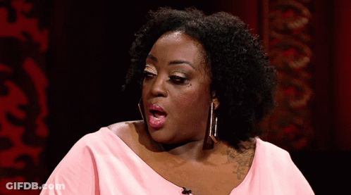 A Woman In A Pink Shirt Is Making A Funny Face With Her Mouth Open GIF