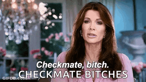 A Woman In A Pink Shirt Is Saying Checkmate Bitch Checkmate Bitches In Front Of A Chandelier . GIF