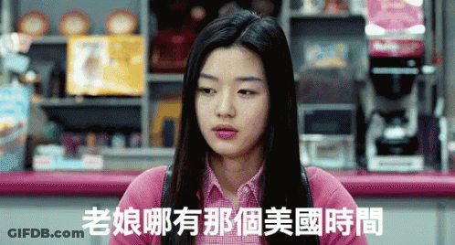 A Woman In A Pink Shirt Is Sitting At A Counter With Chinese Writing On It GIF