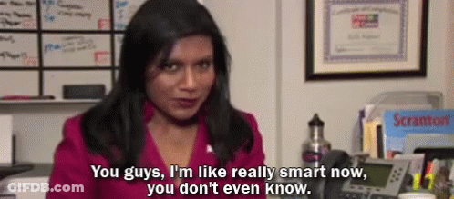 A Woman In A Pink Shirt Is Sitting At A Desk Talking On A Telephone . GIF