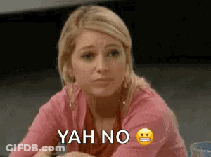 A Woman In A Pink Shirt Is Sitting At A Table With A Smiley Face And The Words `` Yah No '' . GIF