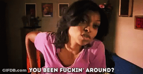 A Woman In A Pink Shirt Is Sitting In A Chair And Talking To Someone . GIF