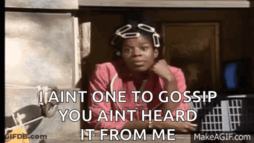 A Woman In A Pink Shirt Is Sitting In Front Of A Window And Talking To Someone . GIF
