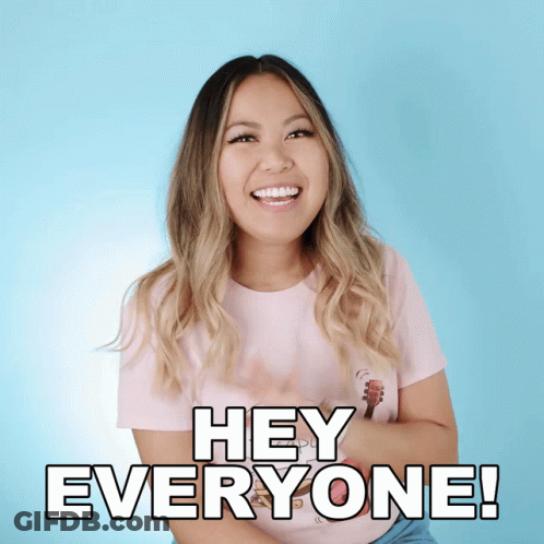 A Woman In A Pink Shirt Is Smiling And Saying Hey Everyone GIF