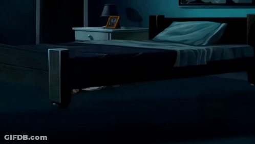 A Woman In A Pink Shirt Is Standing In A Dark Room Next To A Bed GIF