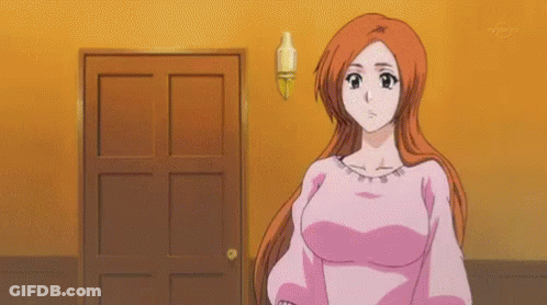 A Woman In A Pink Shirt Is Standing In Front Of A Door In A Room . GIF