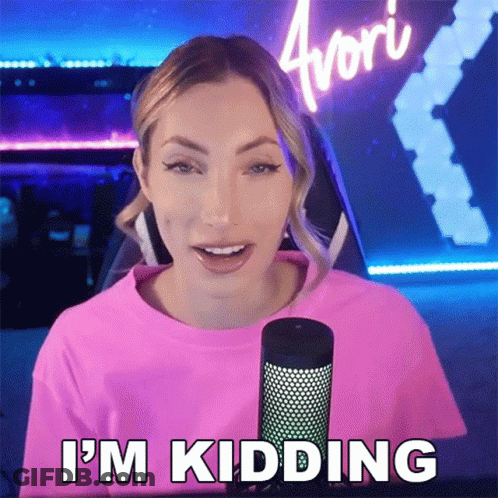 A Woman In A Pink Shirt Is Standing In Front Of A Microphone And Says I 'M Kidding GIF
