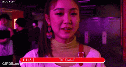 A Woman In A Pink Shirt Is Standing In Front Of A Red Sign That Says ' I 'M Sorry ' . GIF