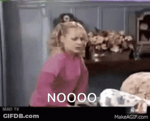 A Woman In A Pink Shirt Is Standing In Front Of A TV Screen That Says Nooo GIF
