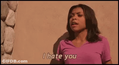 A Woman In A Pink Shirt Is Standing In Front Of A Wall And Saying `` I Hate You '' . GIF