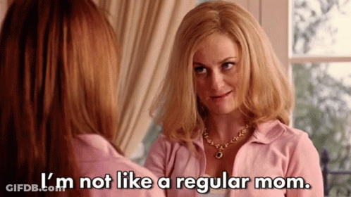 A Woman In A Pink Shirt Is Talking To Another Woman In Front Of A Window . GIF