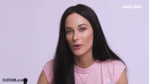 A Woman In A Pink Shirt Says What Happened In White Letters GIF