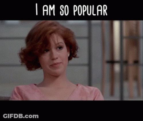 A Woman In A Pink Shirt With The Words " I Am So Popular " Below Her GIF