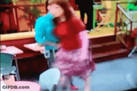 A Woman In A Pink Skirt Is Dancing With A Man In A Blue Shirt In A Blurry Photo . GIF
