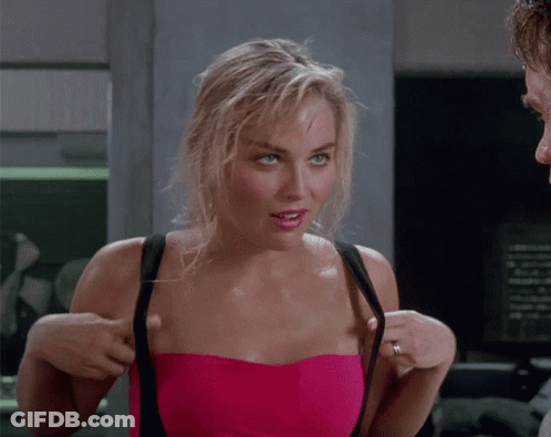 A Woman In A Pink Strapless Top Adjusts Her Straps GIF
