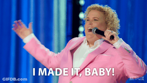 A Woman In A Pink Suit Is Singing Into A Microphone And Says I Made It Baby GIF