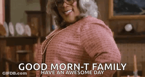 A Woman In A Pink Sweater And Glasses Is Smiling And Says `` Good Morning - T Family Have An Awesome Day '' . GIF