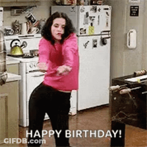 A Woman In A Pink Sweater Is Dancing In A Kitchen With The Words `` Happy Birthday '' Written Below Her . GIF
