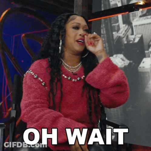 A Woman In A Pink Sweater Is Sitting In A Chair With The Words " Oh Wait " On The Bottom GIF