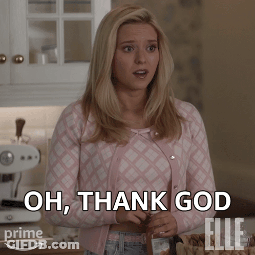A Woman In A Pink Sweater Is Standing In A Kitchen And Says Oh Thank God GIF