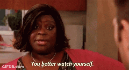A Woman In A Pink Sweater Is Talking To A Man And Says You Better Watch Yourself . GIF