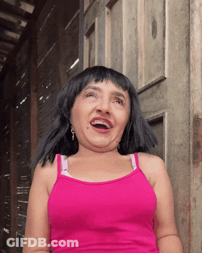 A Woman In A Pink Tank Top Is Making A Face GIF