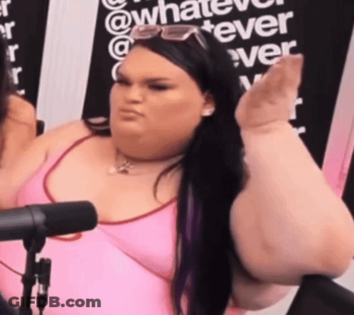 A Woman In A Pink Tank Top Is Sitting In Front Of A Microphone Making A Funny Face . GIF