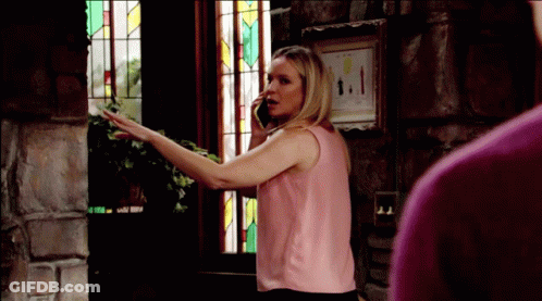 A Woman In A Pink Tank Top Is Talking On A Cell Phone GIF