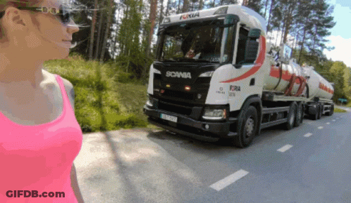 A Woman In A Pink Tank Top Looks At A Scania Truck GIF