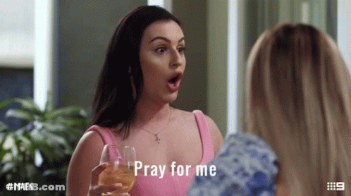 A Woman In A Pink Top Is Holding A Wine Glass And Says Pray For Me GIF