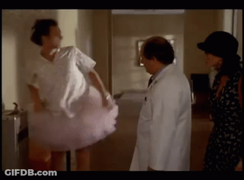 A Woman In A Pink Tutu Is Standing Next To A Doctor And A Woman In A Black Dress . GIF