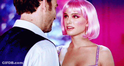 A Woman In A Pink Wig Looks At A Man In A Blue Vest GIF
