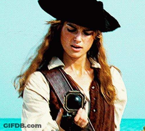 A Woman In A Pirate Costume Is Holding A Cannon GIF
