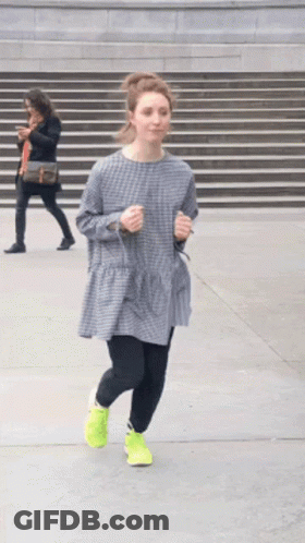 A Woman In A Plaid Dress And Neon Yellow Shoes Is Running Down The Street GIF
