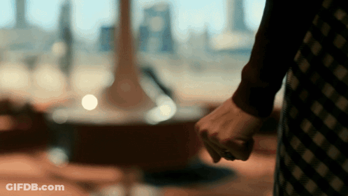A Woman In A Plaid Dress Holds Her Fist Up In A Blurry Photo GIF
