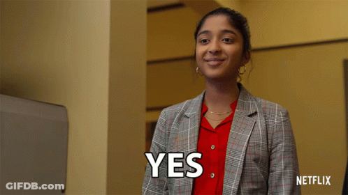A Woman In A Plaid Jacket Is Smiling And Says Yes GIF