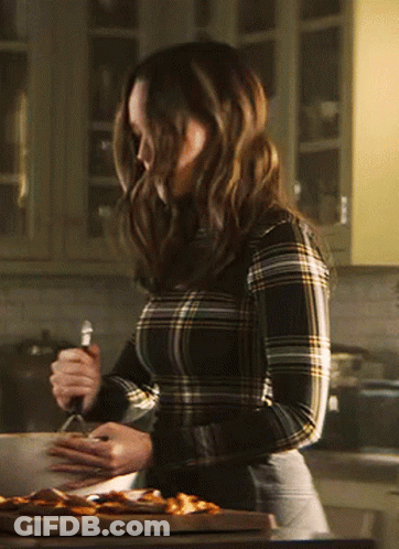 A Woman In A Plaid Shirt Is Cooking In A Kitchen GIF