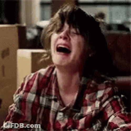 A Woman In A Plaid Shirt Is Laughing And Crying . GIF