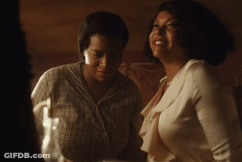 A Woman In A Plaid Shirt Is Laughing With Another Woman In A White Shirt GIF