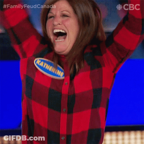 A Woman In A Plaid Shirt Is Raising Her Arms In The Air GIF