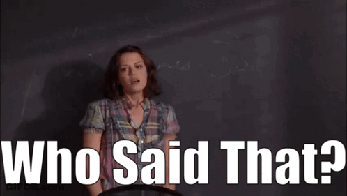 A Woman In A Plaid Shirt Is Standing In Front Of A Blackboard With The Words Who Said That . GIF