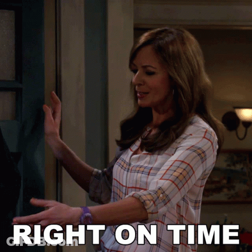 A Woman In A Plaid Shirt Is Standing In Front Of A Door With The Words Right On Time Behind Her GIF
