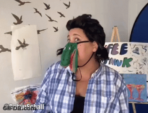 A Woman In A Plaid Shirt Is Standing In Front Of A Sign That Says Free Swank GIF